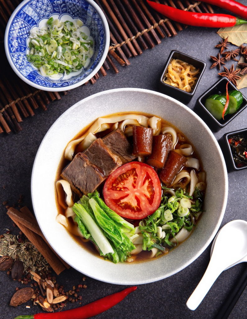 台北萬豪酒店的「經典半筋半肉牛肉麵」,以秘方熬煮四十八小時的上乘湯頭,搭配軟嫩的滷製無骨牛小排、彈牙牛筋,佐上特製辣味牛油與刀削麵,呈獻令人欲罷不能的誘人滋味。(圖/台北萬豪酒店)