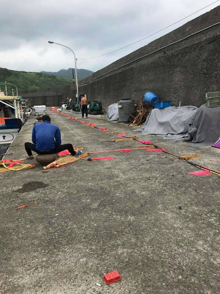 北臺灣目前唯一的馬崗漁港飛魚追逐網船隊，休息時漁民在港邊整補驅趕繩 圖／新北市漁業處提供