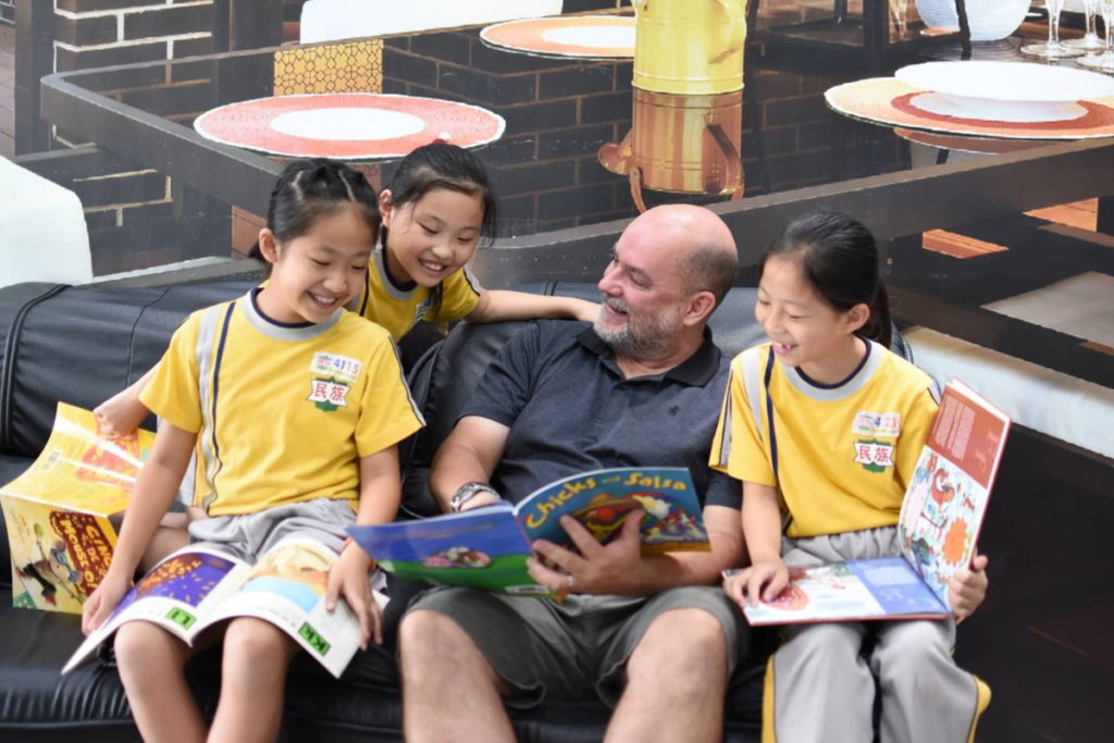 外籍教師與學生共讀英語圖書(資料照)