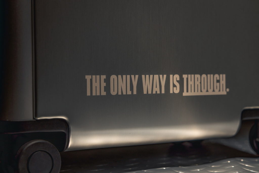 Team UA專屬應援行李箱,外觀刻上「THE ONLY WAY IS THROUGH (戰勝是唯一的路)」品牌精神字樣。