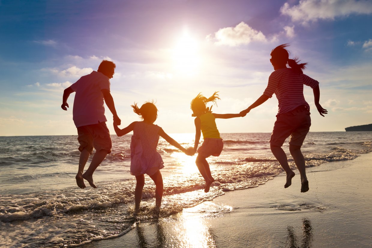 Happy,Family,Jumping,Together,On,The,Beach
