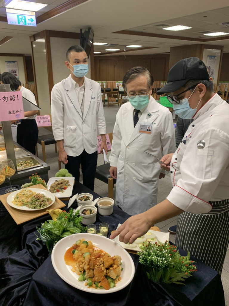 灃食美味革新主廚林奕成(右一)向臺中慈濟醫院院長簡守信(中)說明菜色內容。