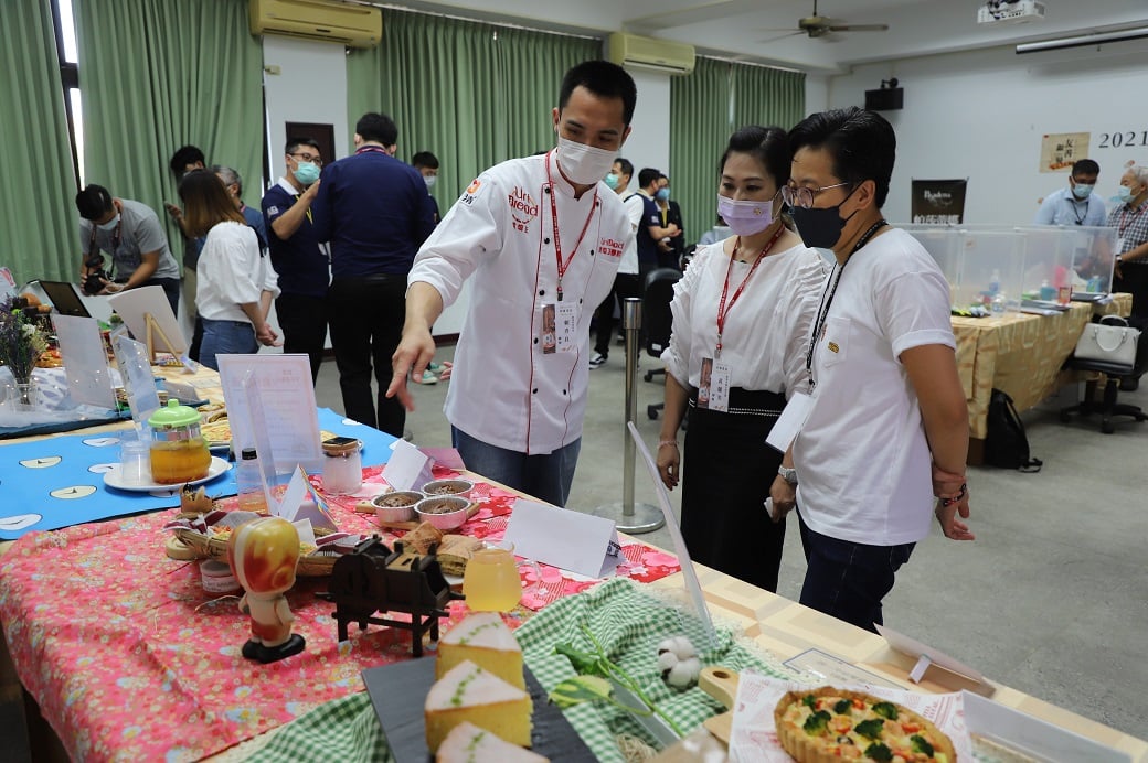 可能是 3 個人、大家站著、食物和室內的圖像