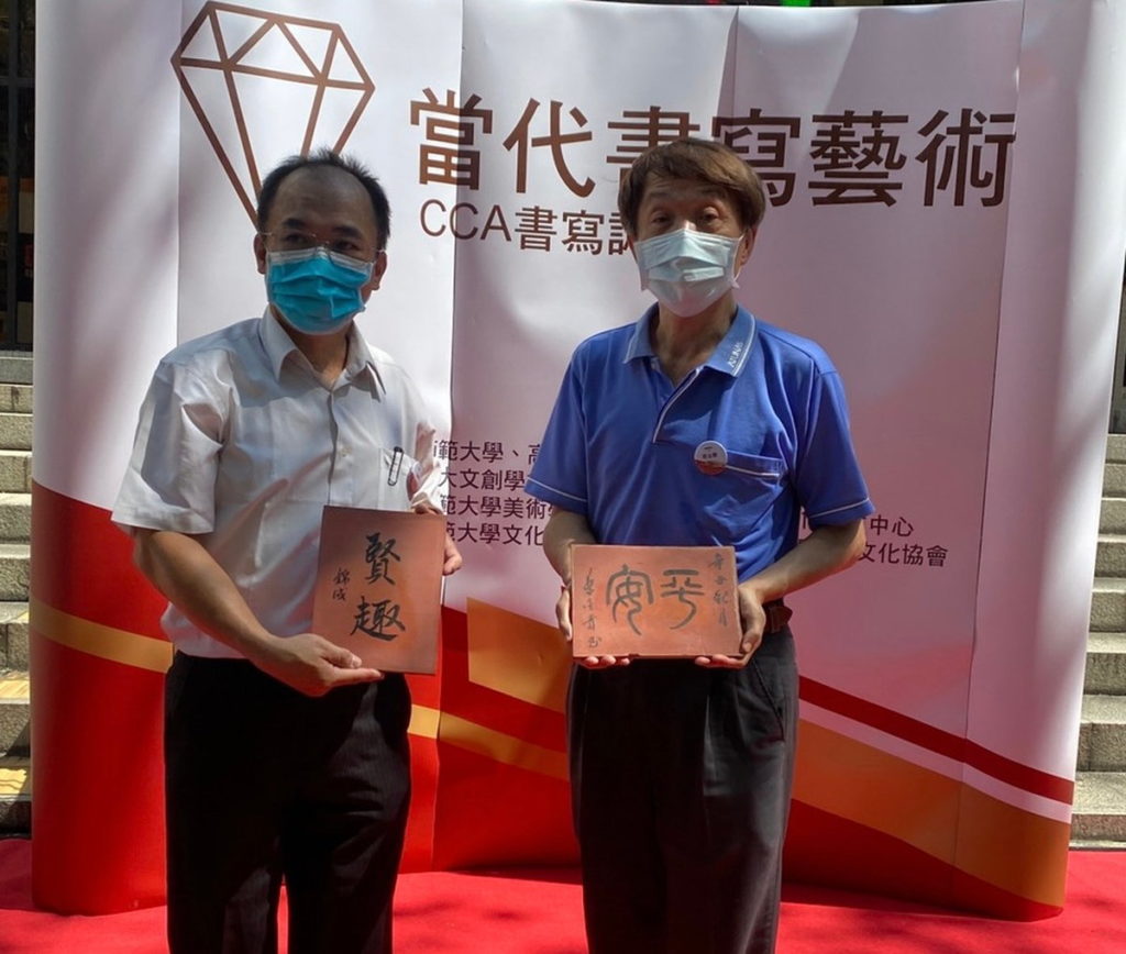 理事長王錦成(左)與高雄市中華書道協會理事長蔡金貴揮毫合影