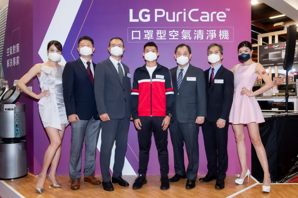 台灣 LG 電子今於台北3C電器空調影音展舉辦「升級版 LG PuriCare口罩型空氣清淨機」媒體分享會，左起主持人、空調家電產品部總監李鏞國、董事長宋益煥、湯智鈞、資深副總經理羅時景、創新生活家電事業部協理陳慶全、展示MODEL
