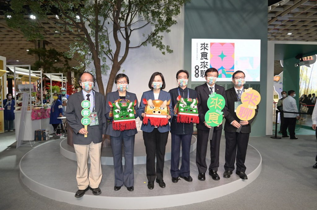 客家館首創「將大樹搬進旅展」，在旅展裡再現客家庄內的日常風景，要讓大家一起在大樹下體驗客家文化、共享客家美食。
