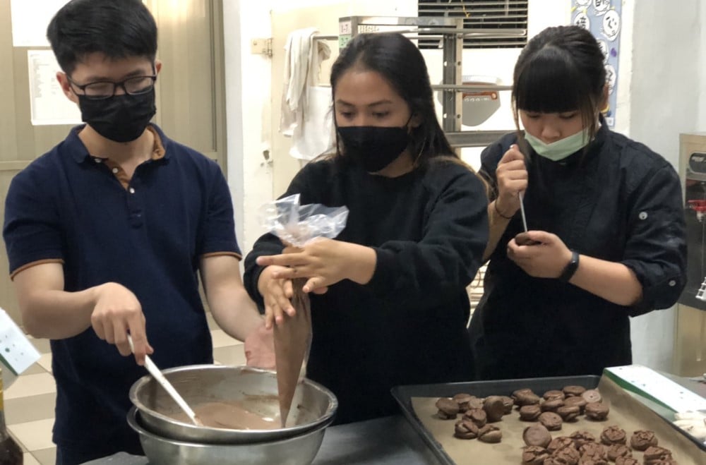 可能是 3 個人、大家站著和室內的圖像