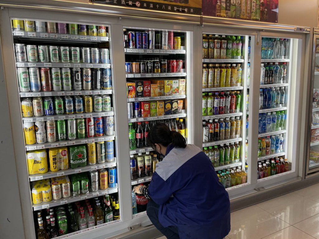 萊爾富北市信彩店今日上午十時冰箱門已拆除，店員正忙著整理冰箱內飲品
