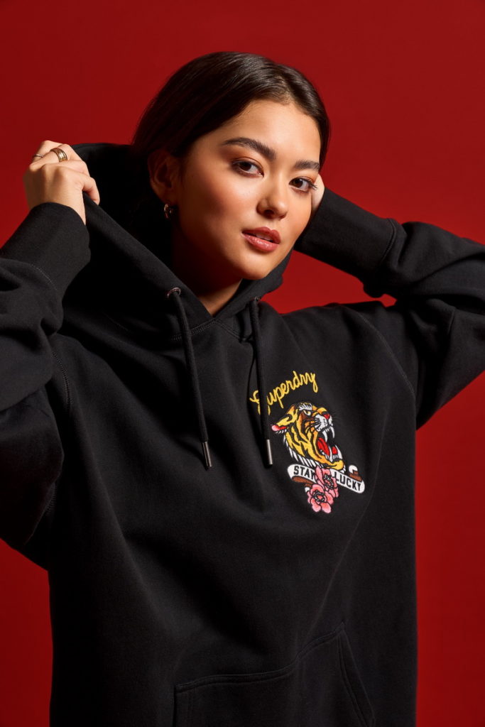 SUPERDRY新春系列服飾女款連帽連身裙版型硬挺,搭配嘶吼虎頭造型圖案,過年也能一件酷帥走春。