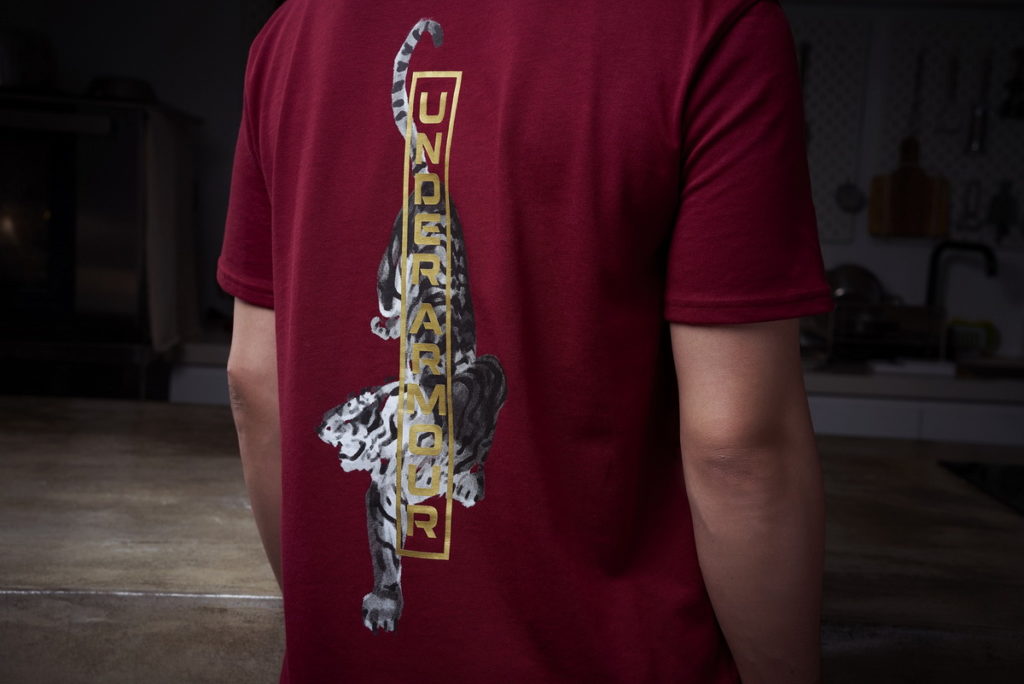 UNDER ARMOUR CNY新春限定服飾結合蓬勃朝氣的老虎水墨畫與標楷漢體「虎」字元素,象徵新的一年如猛虎般氣宇軒昂的吉祥寓意。