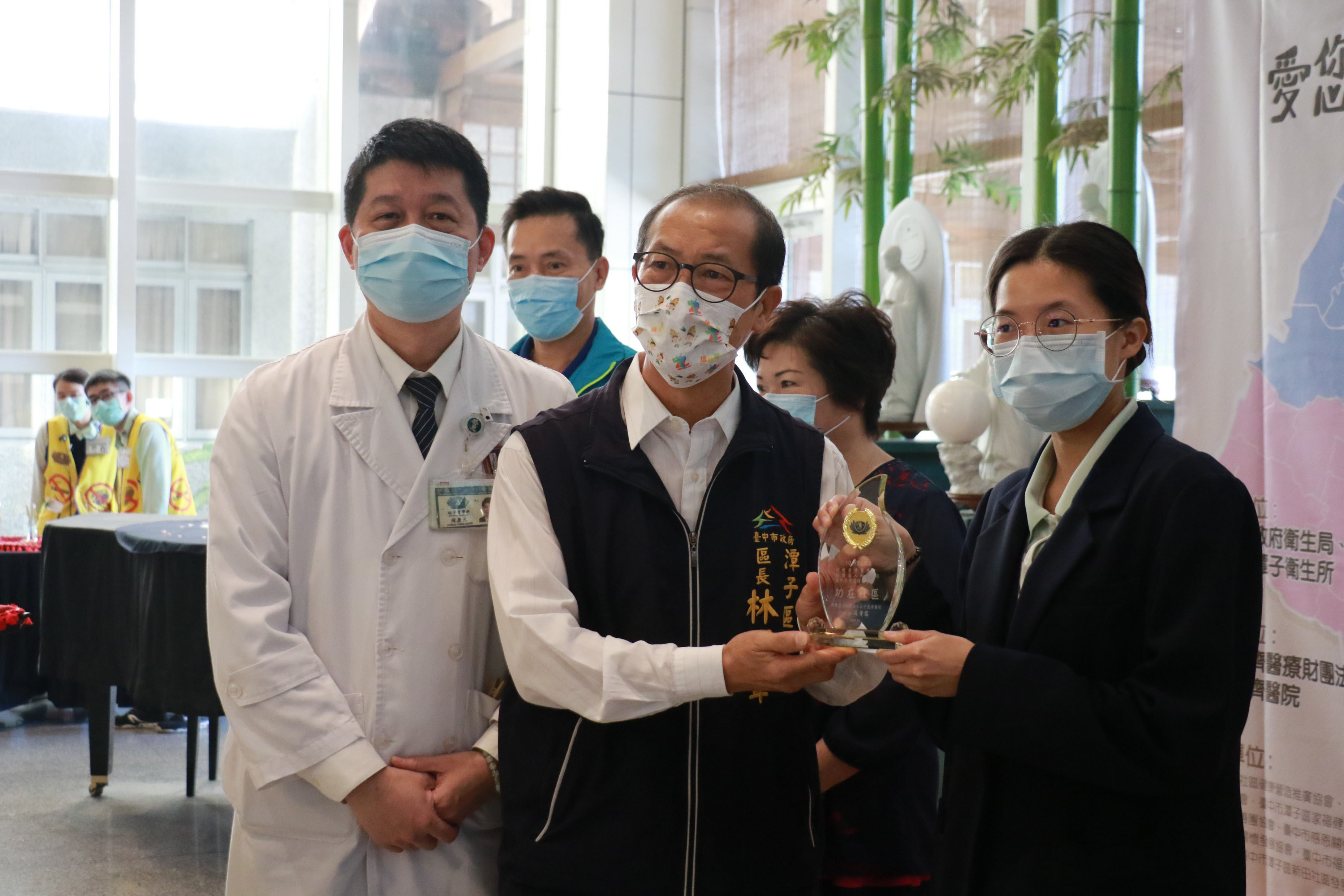 臺中慈濟醫院社區健康中心主任陳慶元(左起)、潭子區長林國聲頒發「功在社區」獎座給臺中慈濟護理之家。