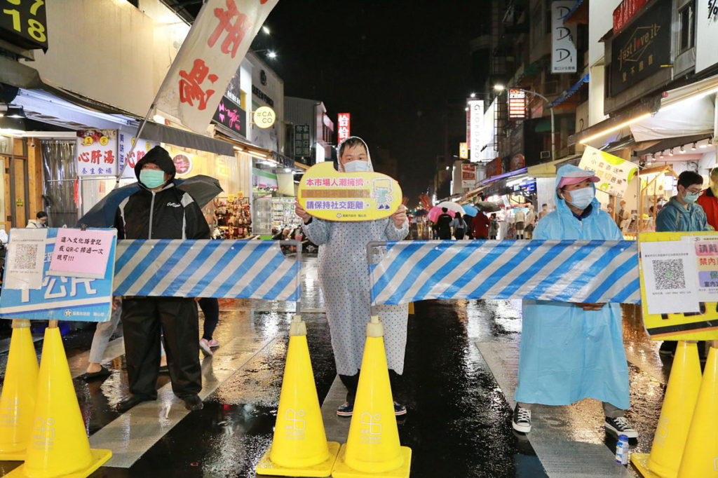 路口處舉牌提醒民眾遵守防疫規定