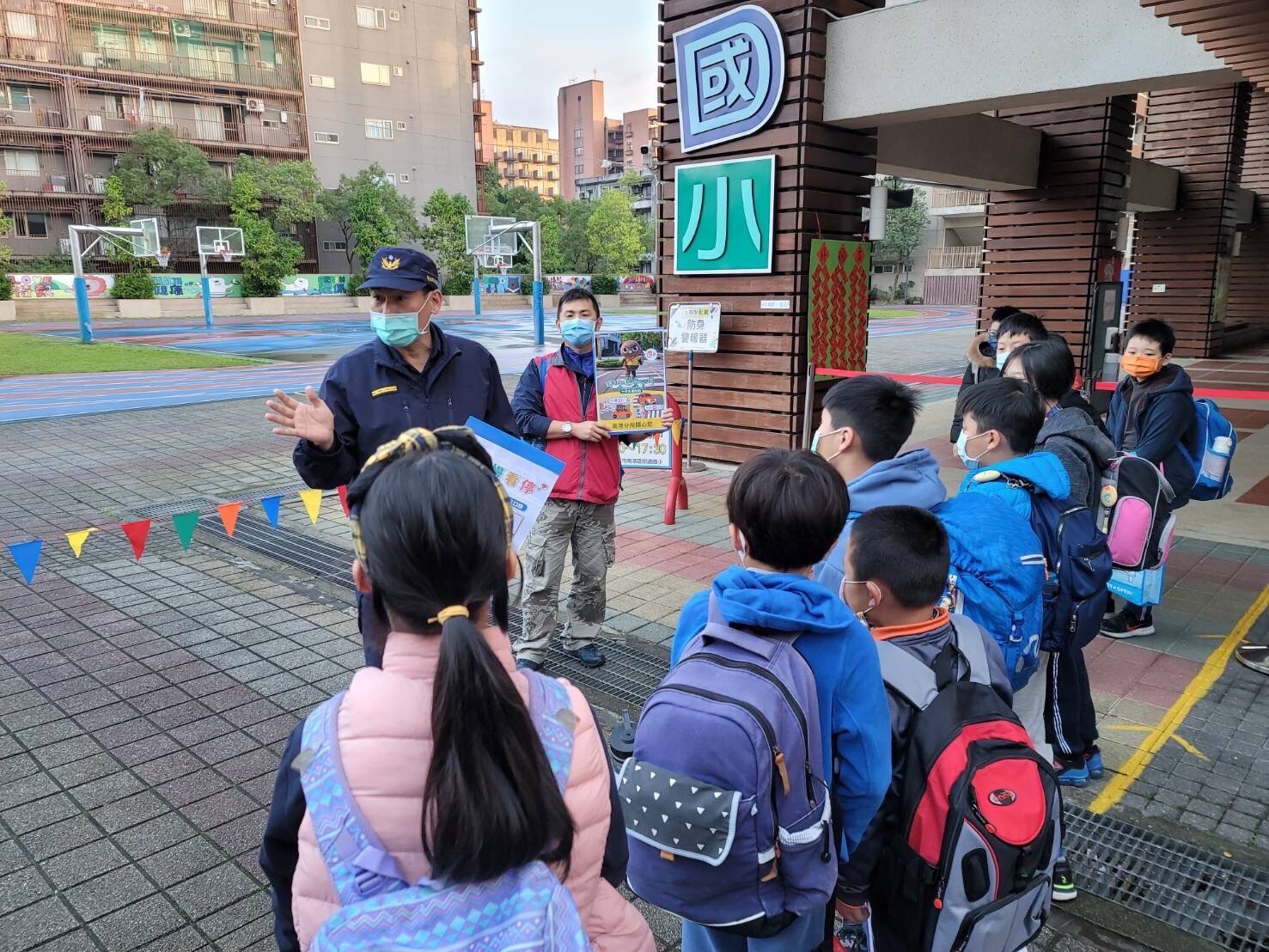 圖片說明:南港警在學童上學途中向其宣導交通安全觀念。 (記者林艷林翻攝)