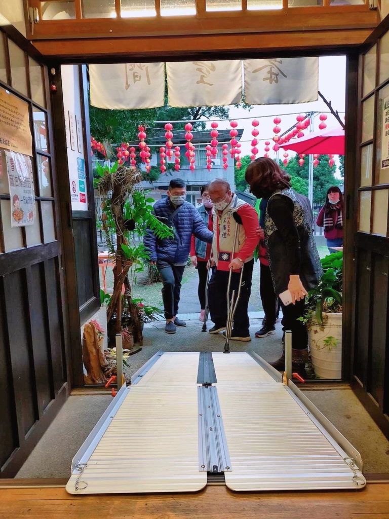 王廣禮里長拄著拐杖上斜坡板