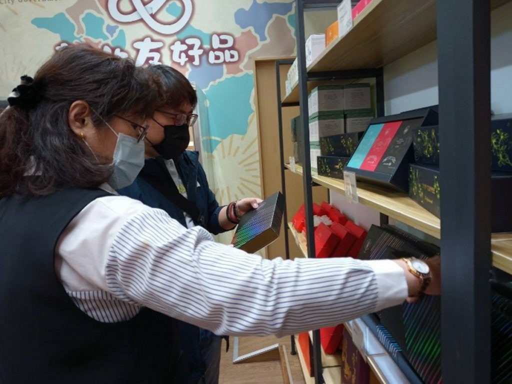 經發局何怡明局長在調整商品櫃位,以利遊客選購。