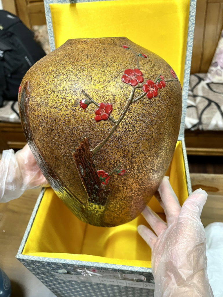 古梅漆瓶,不似一般表面光滑的漆面,紋理是貼金後磨顯完成,上了朱漆的紅梅顏色華