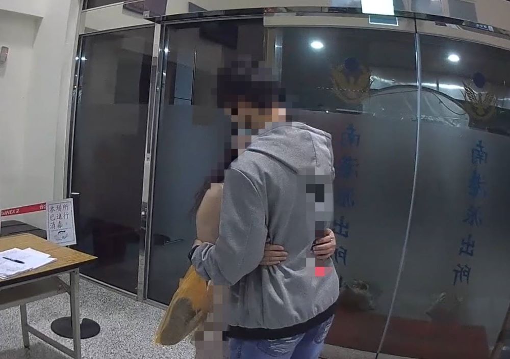 婦人於子親情勸說後與子擁抱。