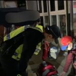 ▲深夜時分,李婦與其身心障礙兒子佇立街頭,低頭查看電動代步車,員警趨前關心 (圖/苗栗縣警察局 提供