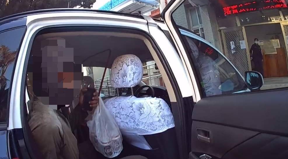 ▲因男子已有酒意,繼續坐在欄杆上易生危險,員警以警車將男子載回後龍分駐所 (圖/苗栗縣警察局 提供)