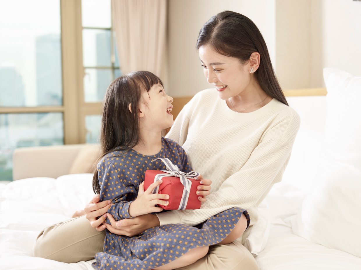 Happy,Little,Asian,Girl,Sitting,In,Arms,Of,Young,Loving