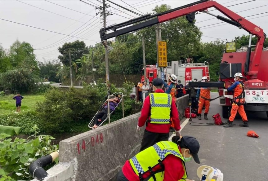 ▲消防搜救隊員以吊車成功將男子救回橋上，並由救護車將傷者緊急送醫    (圖/苗栗縣警察局 提供)