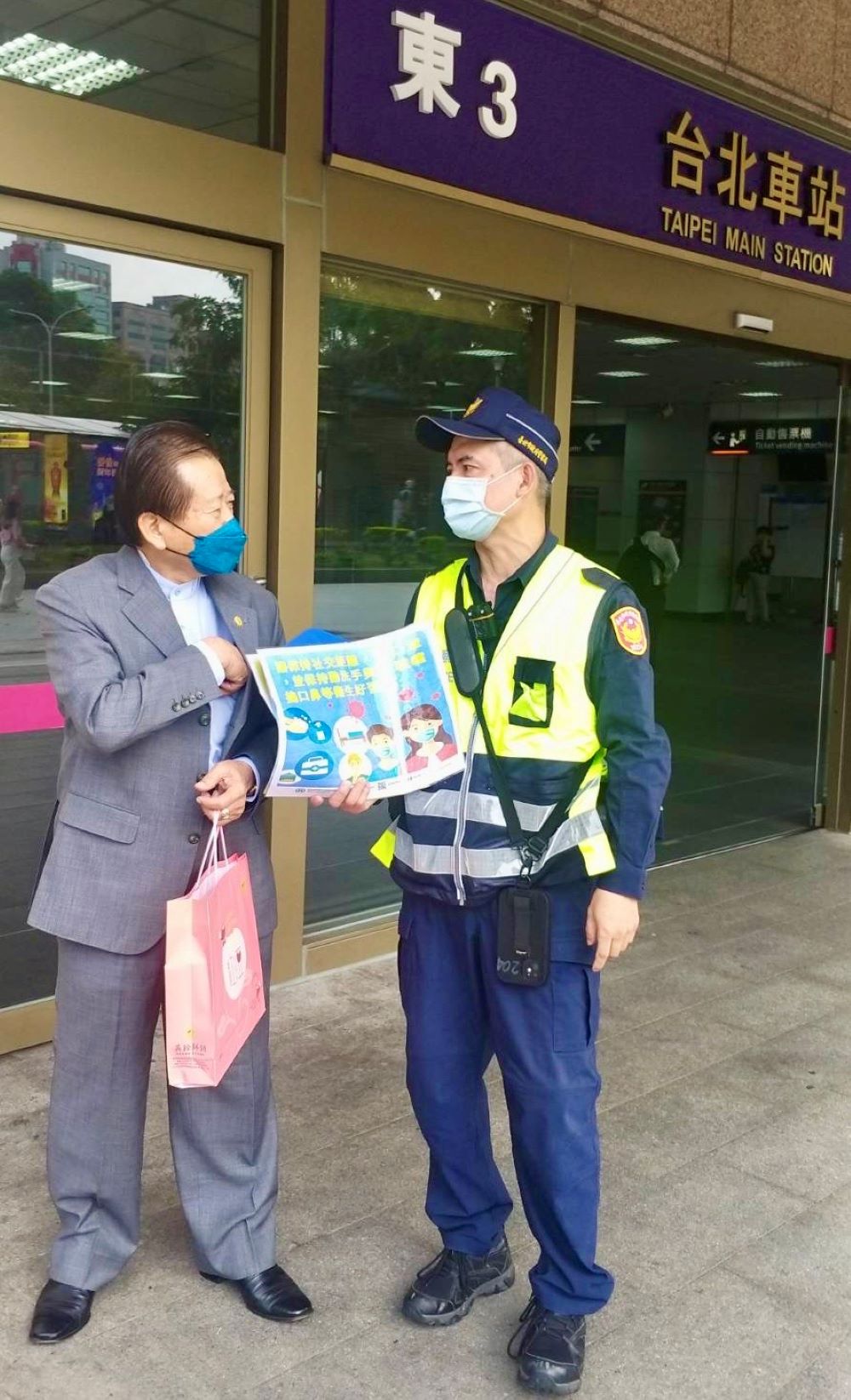 圖片說明:臺北市保安警察大隊手持防疫宣導海報,在臺北車站各出入口處徒步巡邏,執行防疫宣導活動。(記者宋紹誠翻攝)