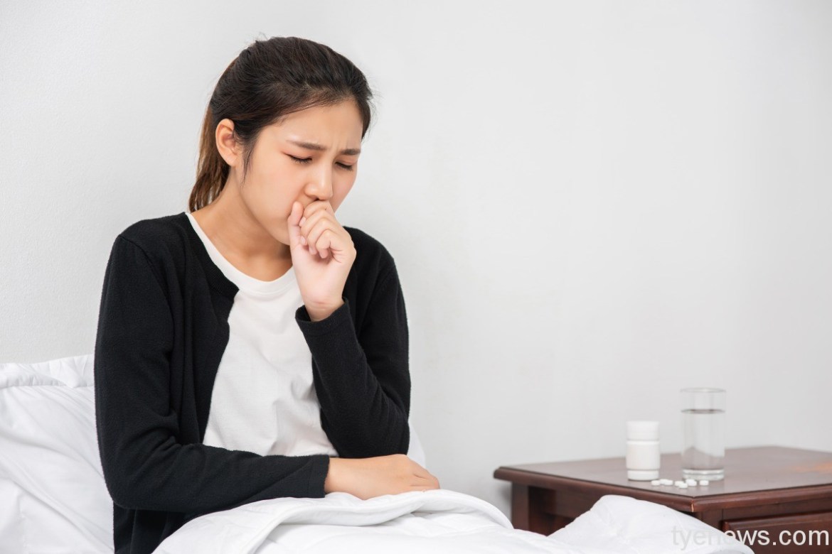 woman coughed covered her mouth with her hand sat bed