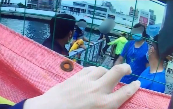 圖片說明:民眾「即刻救援」,使用救生圈將在海中載浮載沉的男子救上岸。(記者宋紹誠翻攝)