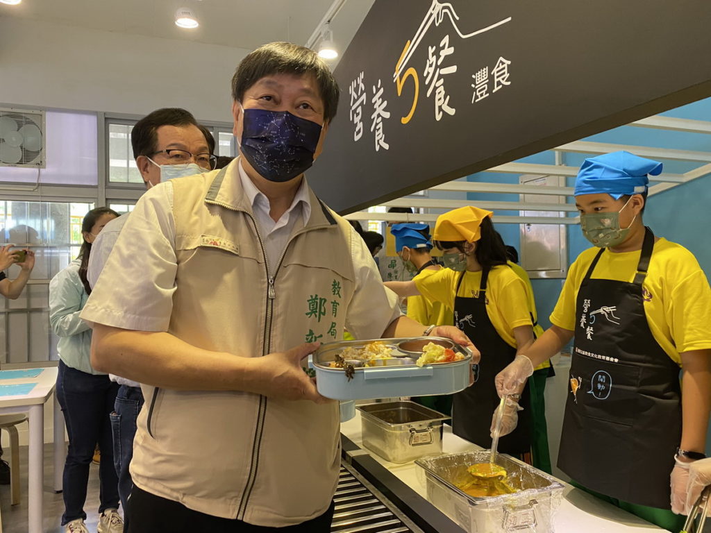 ▲ 日新國小同學為教育局長鄭新輝打菜,品嘗美味午餐。