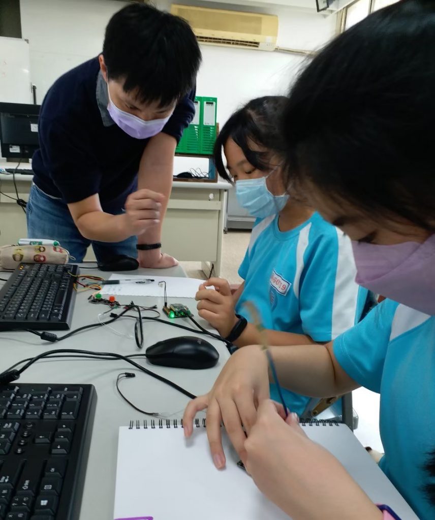 廣福國小邱贊全老師(左)指導學生修正電子模組