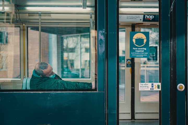 man in face mask sleeping in train