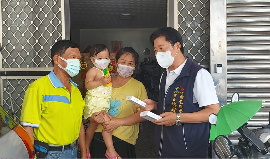 圖片說明：南屯里長林秋潭與鄰長至民眾家戶發送自己照顧2-12歲孩童快篩。(記者謝榮浤翻攝)