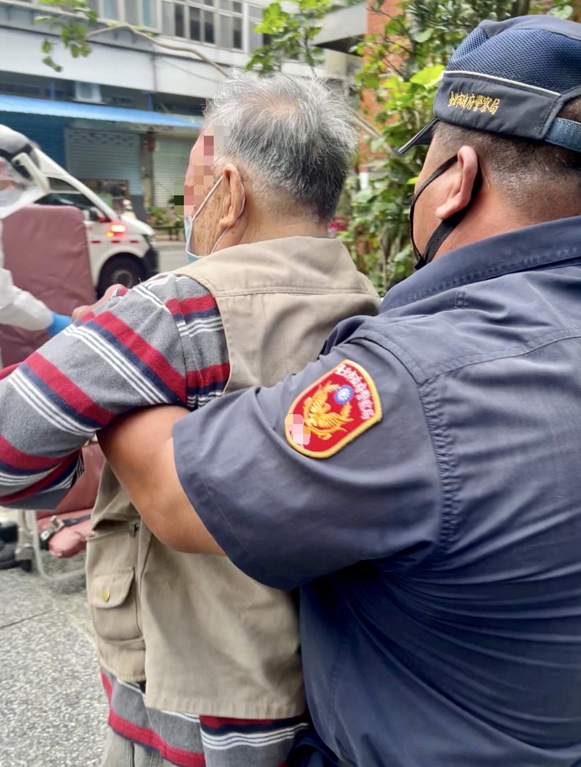 圖片說明:臺北市保安警察大隊警員易法華立刻通報消防局派遣救護車到場救護,並協助攙扶傷者上救護擔架送醫診治。(記者宋紹誠翻攝)