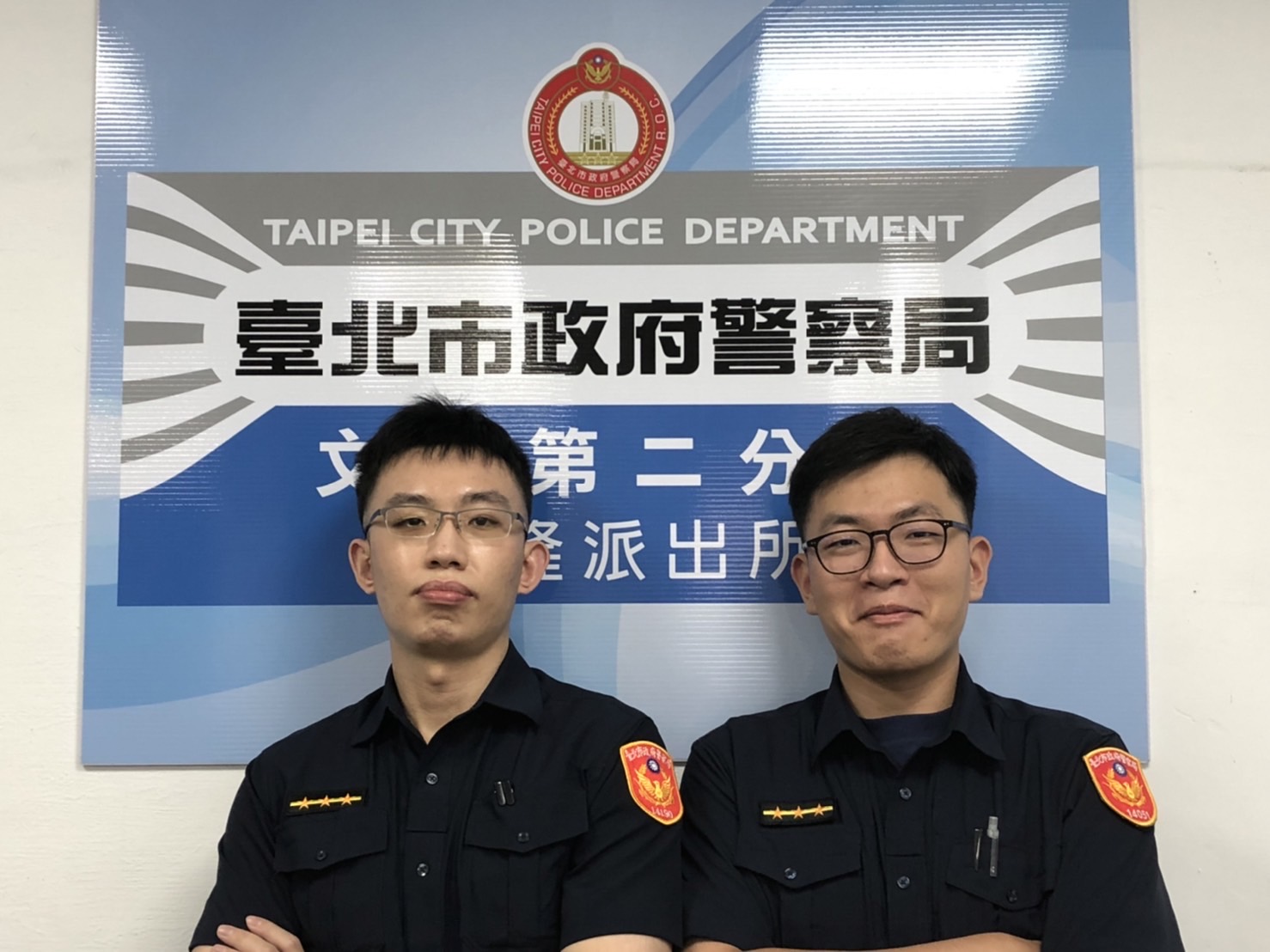 圖片說明:興隆所警員景暐傑(左)、陳則輔(右)接獲民眾至所內求助,速協助就醫。(記者趙靜姸翻攝)