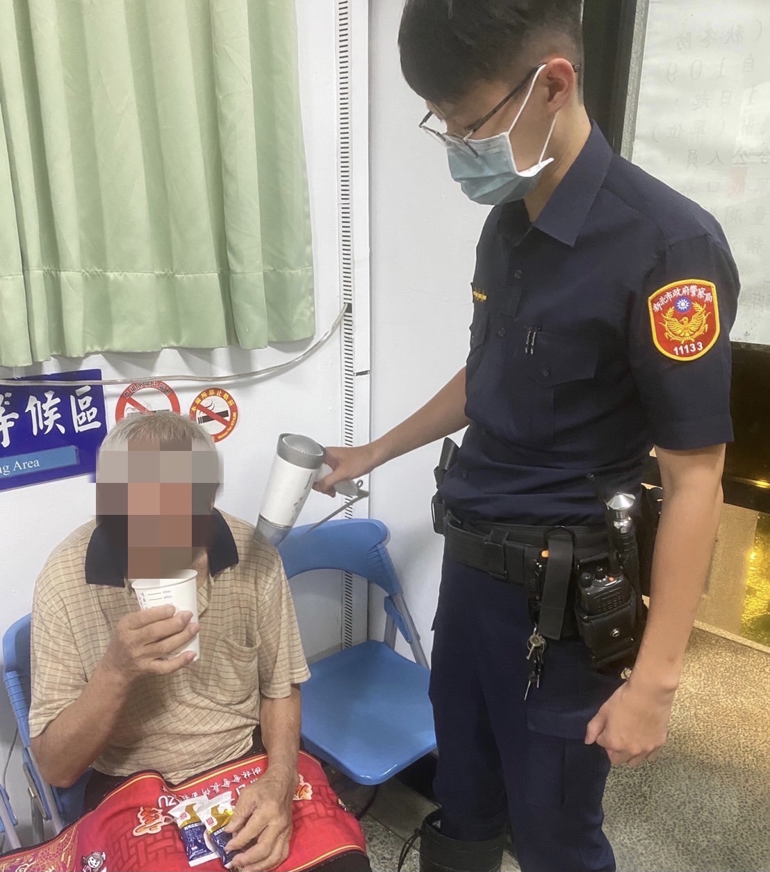圖片說明:樹林暖警親自幫老翁吹乾淋濕衣物。(記者徐煜勝翻攝)