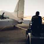 baggage carrier on airfield with plane