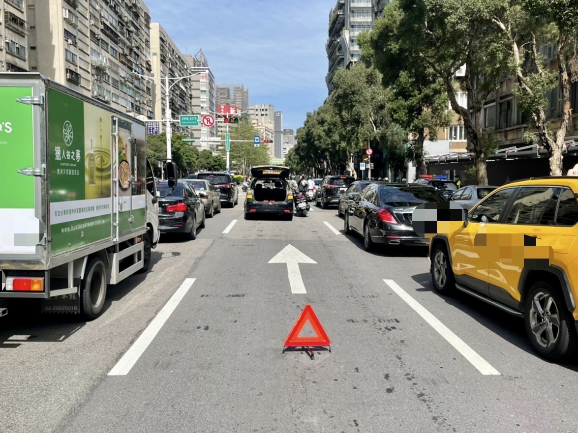 圖片說明:臺北市保安警察大隊啟動交通快打,迅速疏導車輛由兩側車道慢速通行,並擺放三角反光板警示拉長安全距離、現場拍照及標記事故車輛記號。(記者宋紹誠翻攝)