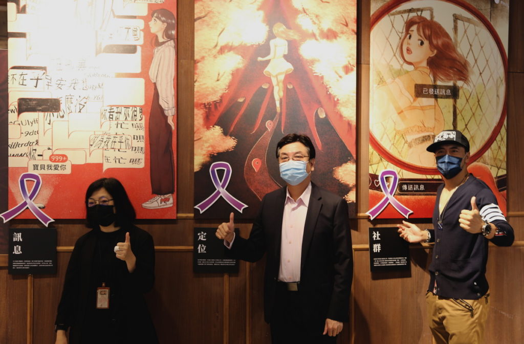 新北市副市長劉和然(中)、路易莎咖啡董事長黃銘賢(右)、東吳大學社會工作學系教授廖美蓮(左),一同在被害人心境畫作上別上象徵暴力零容忍的紫絲帶,呼籲終止數位親密關係暴力。