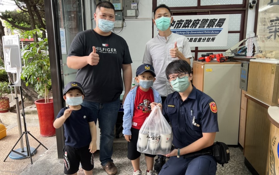 ▲小小兄弟檔提著一大袋飲料,高興的對「心目中的英雄」說「警察節快樂!」 (圖/台中大甲分局 提供)