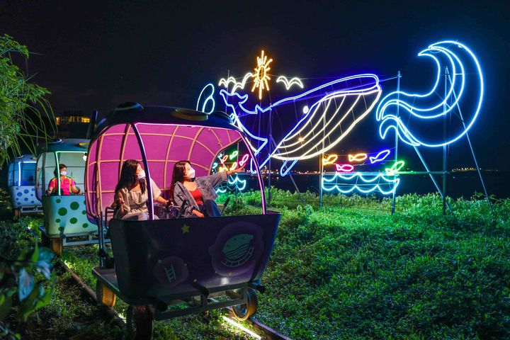 迎著海風騎乘鐵道自行車,各種璀璨燈飾閃耀迷人光輝。 圖:新北市政府觀光旅遊局/提供