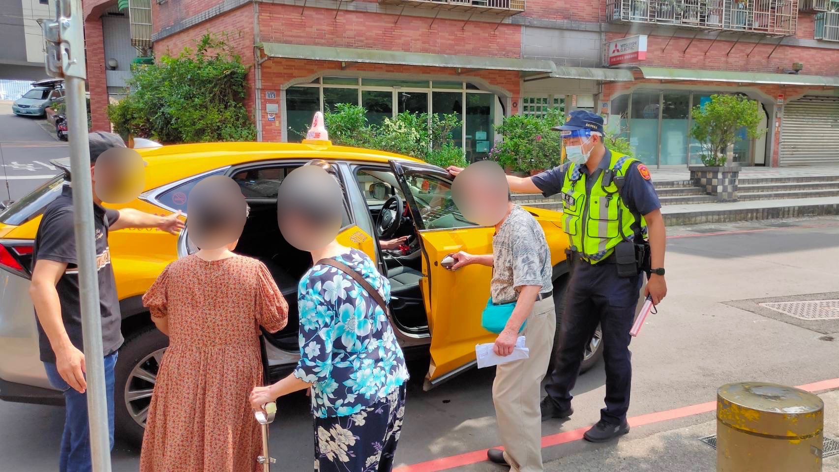 圖片說明:基隆市警第一分局員警在仁愛區公所外即時疏導車輛並視狀況協助長者上、下車。(記者宋紹誠翻攝)
