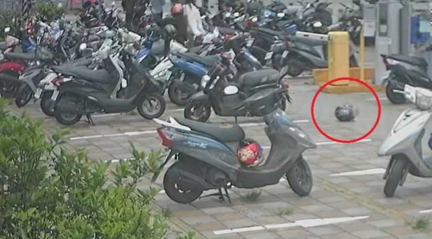 ▲一陣大風吹過,黃女的安全帽滾落至附近黑色機車旁的地面 (圖/台中市警察局 提供)