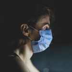 close up shot of a woman wearing blue face mask