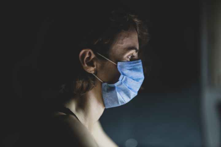 close up shot of a woman wearing blue face mask