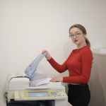 serious female office worker using printer in workplace
