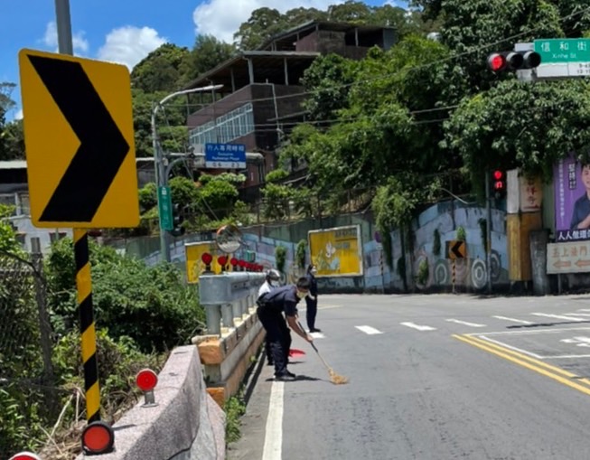 樹林分局山佳派出所警員張育齊、林韻慈 立即於現場實施交通管制，並向附近住戶借畚箕、掃把，一員在場交管