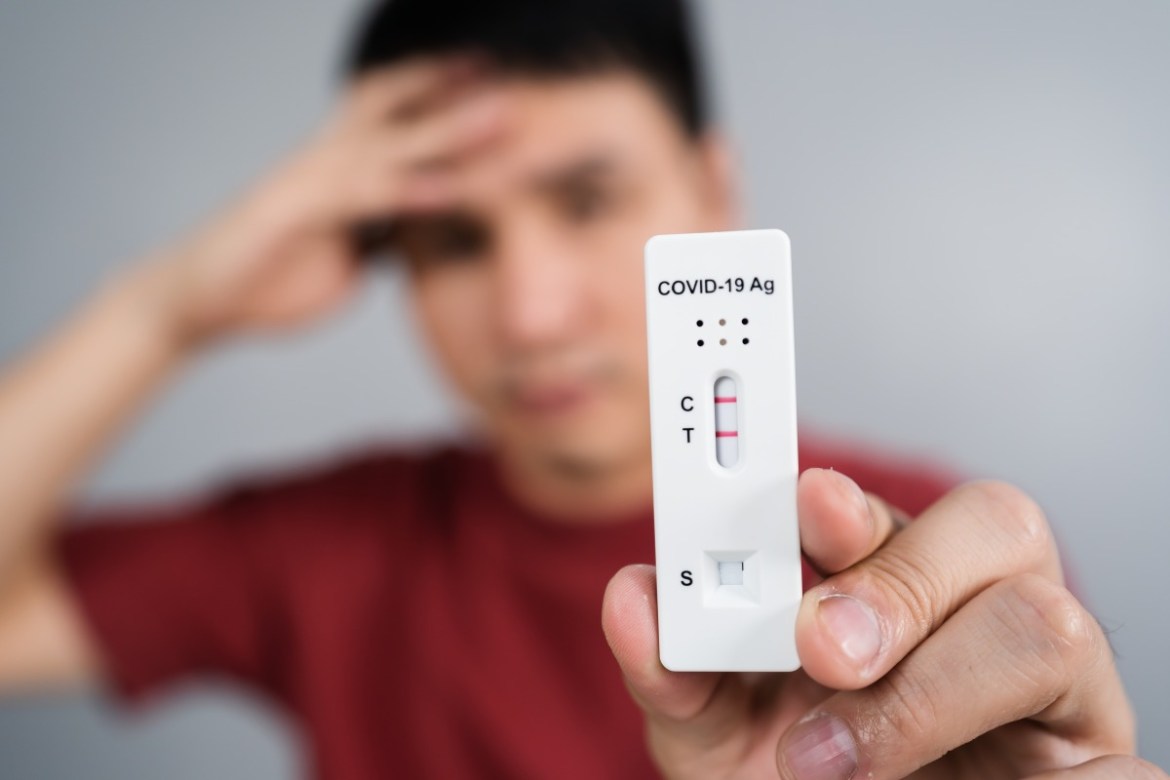 桃園7/15本土新增2711例 BA.5威力忽輕忽 19 young stressed man holding coronavirus covid 19 positive test result with antigen rapid test kit atk