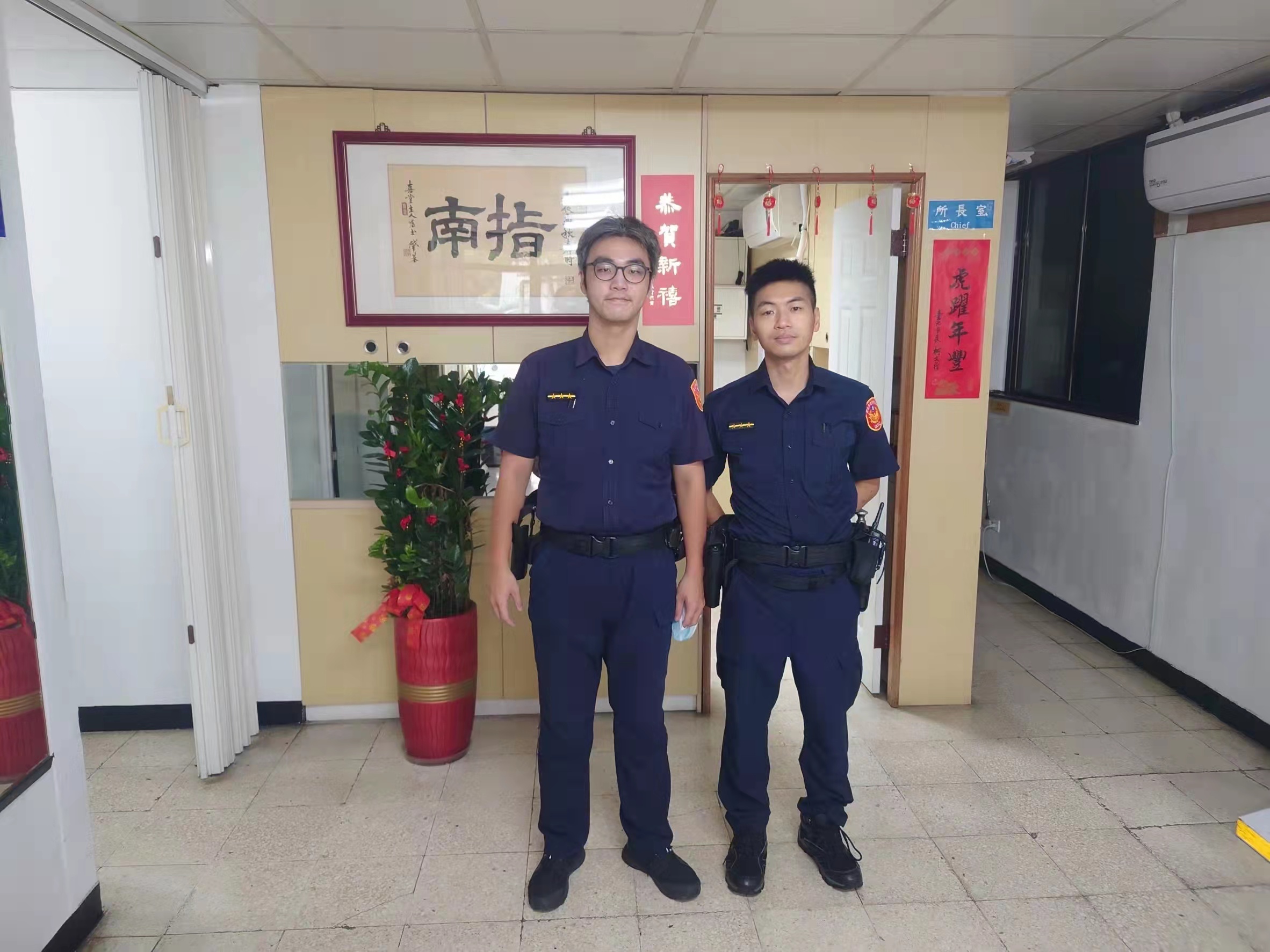 圖片說明:指南派出所警員龍顗凱(左)、警員鄭宇倫(右)根據一張捐款感謝狀機智協助老婦返家。(記者吳萍翻攝)