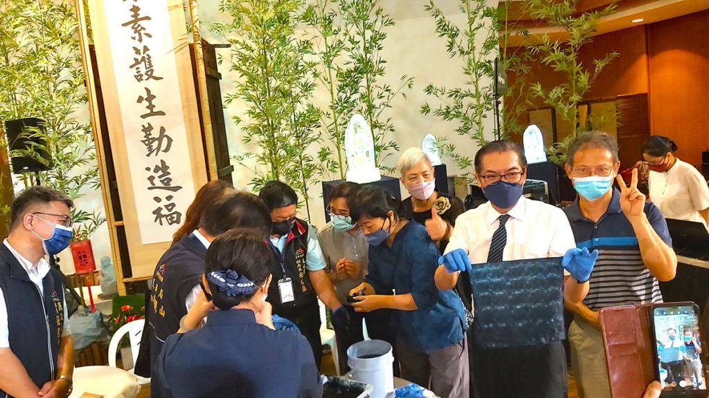 何日生帶領台中市府貴賓現場體驗藍染。(圖/陳惠玲攝影)