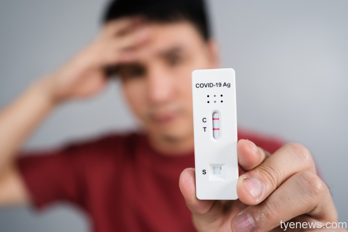 桃園7/29本土增2392例 7/30再開嬰幼兒疫苗快打站 14 young stressed man holding coronavirus covid 19 positive test result with antigen rapid test kit atk 1